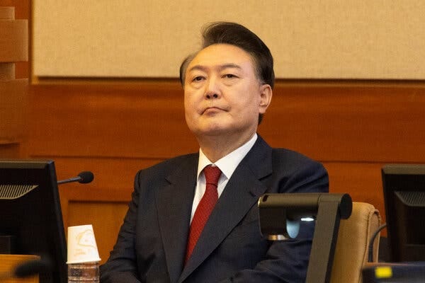 Yoon Suk Yeol sits in a chair in a courtroom. Yoon Suk Yeol sits in a chair in a courtroom.