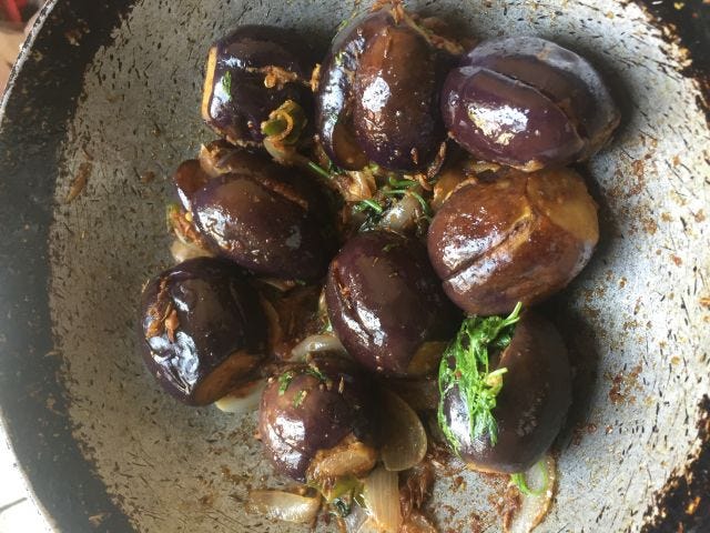 Stuffed baingans, onions and coriander in a pan Stuffed baingans, onions and coriander in a pan