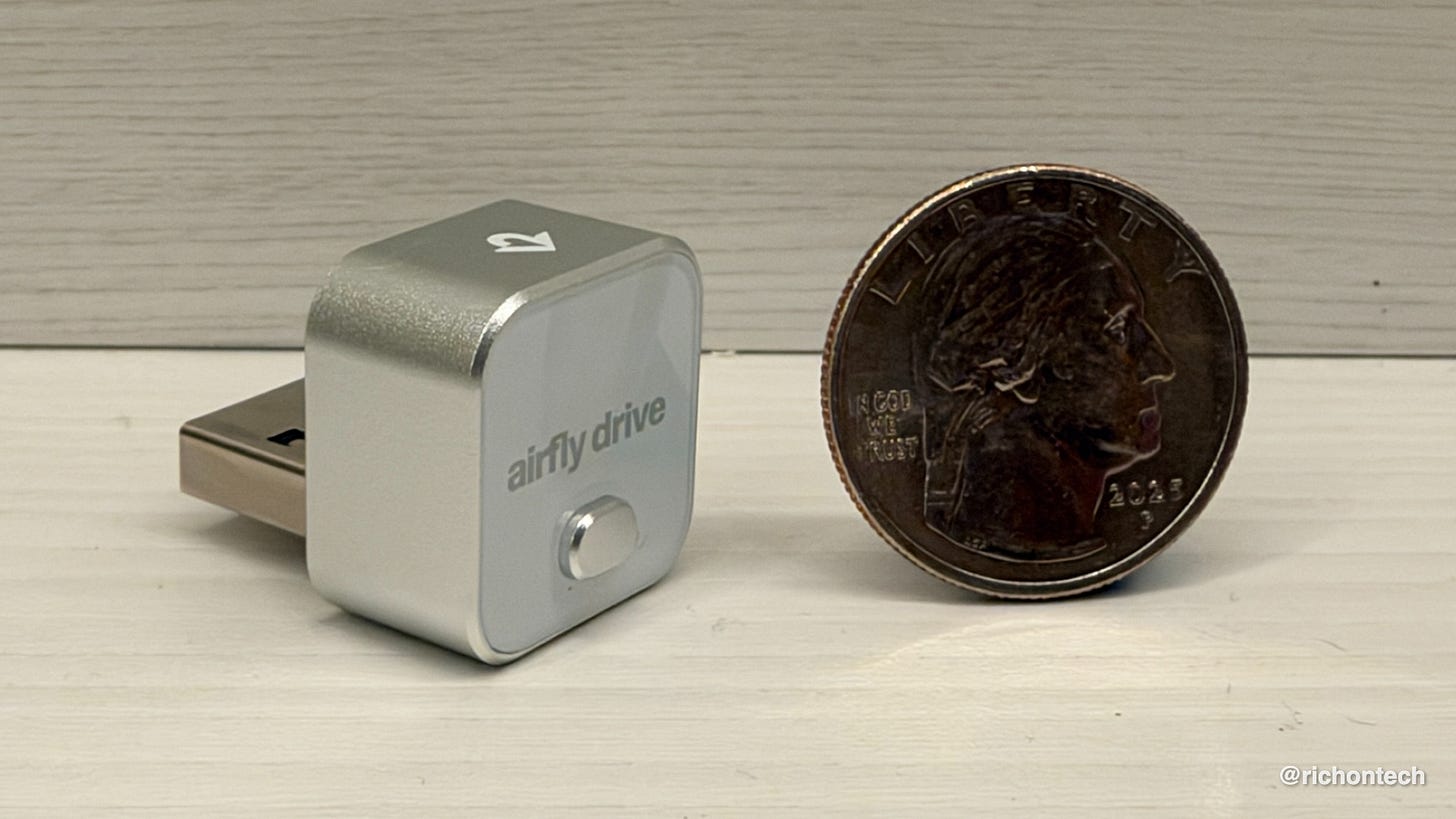 AirFly Drive wireless audio adapter shown next to a U.S. quarter for size comparison. AirFly Drive wireless audio adapter shown next to a U.S. quarter for size comparison.