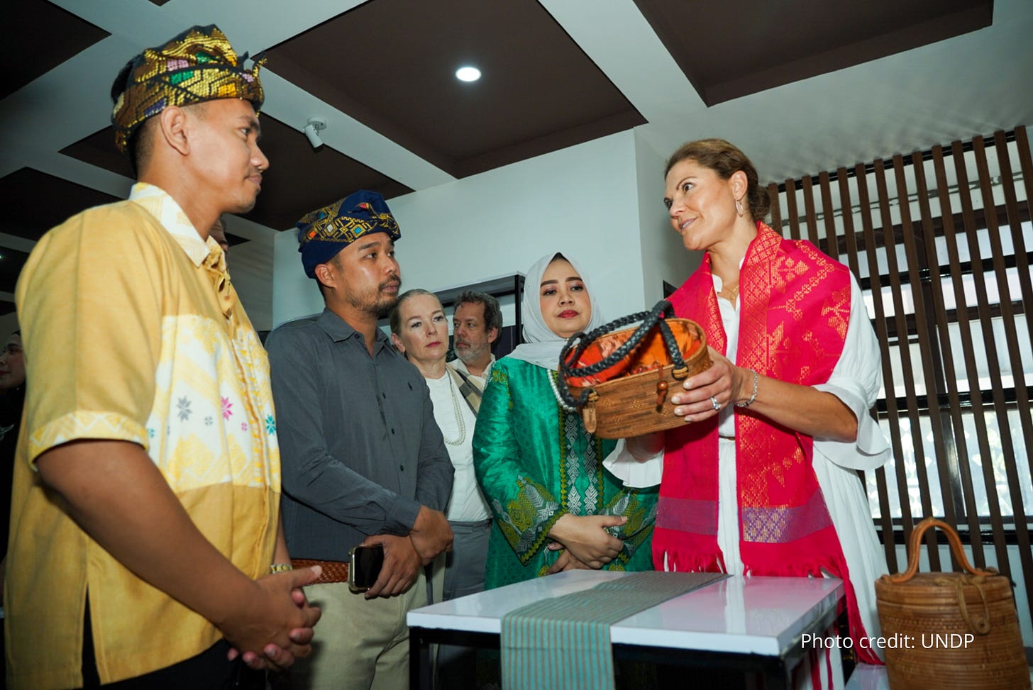 Swedish Crown Princess Victoria talks with a local entrepreneur about his products at BALE KITA
