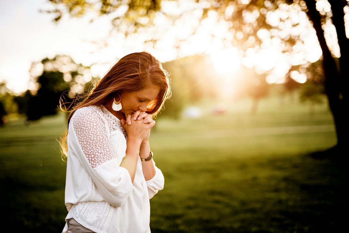 Photo of a woman praying. Photo by Ben White via Unsplash.