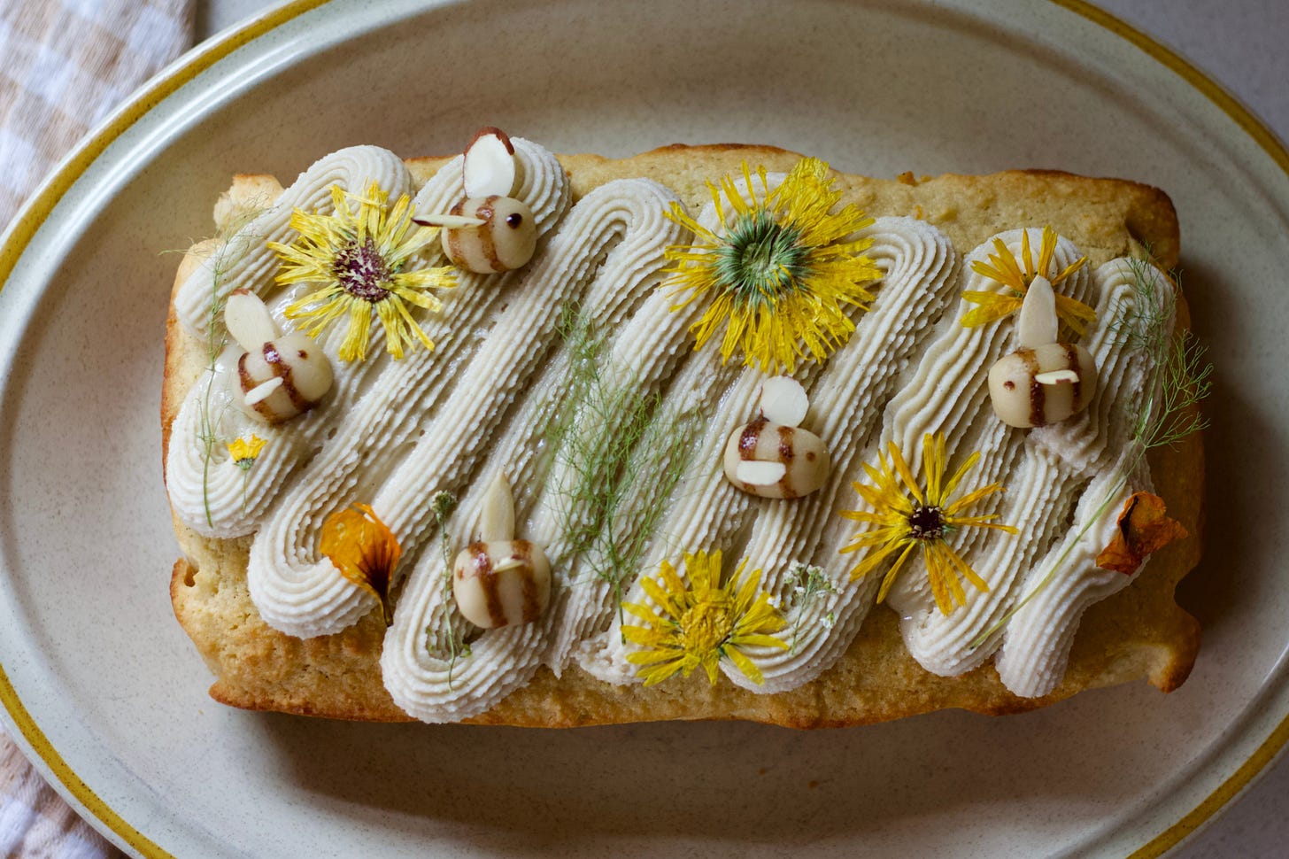 Citrus almond cake with creamy cashew frosting on a white plate with yellow trim Citrus almond cake with creamy cashew frosting on a white plate with yellow trim