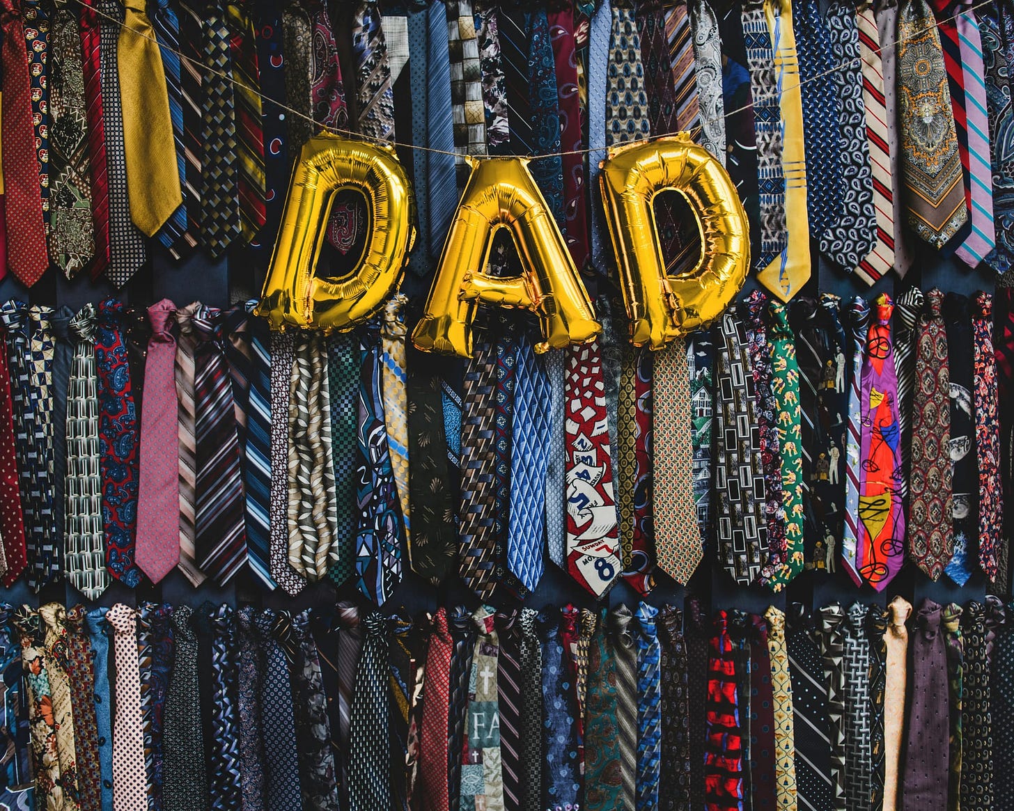 "DAD" balloons draped in front of a wall of suit ties "DAD" balloons draped in front of a wall of suit ties