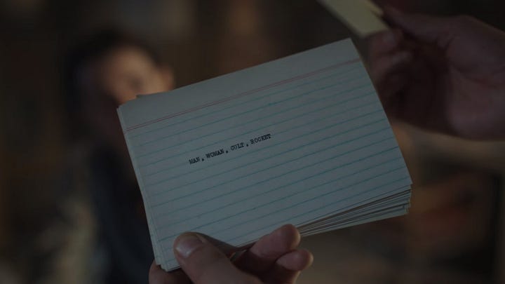 A notecard that says "Man, Woman, Cult, Rocket" and a notecard that says "Boxer, Vigilante, Organ Harvesting"