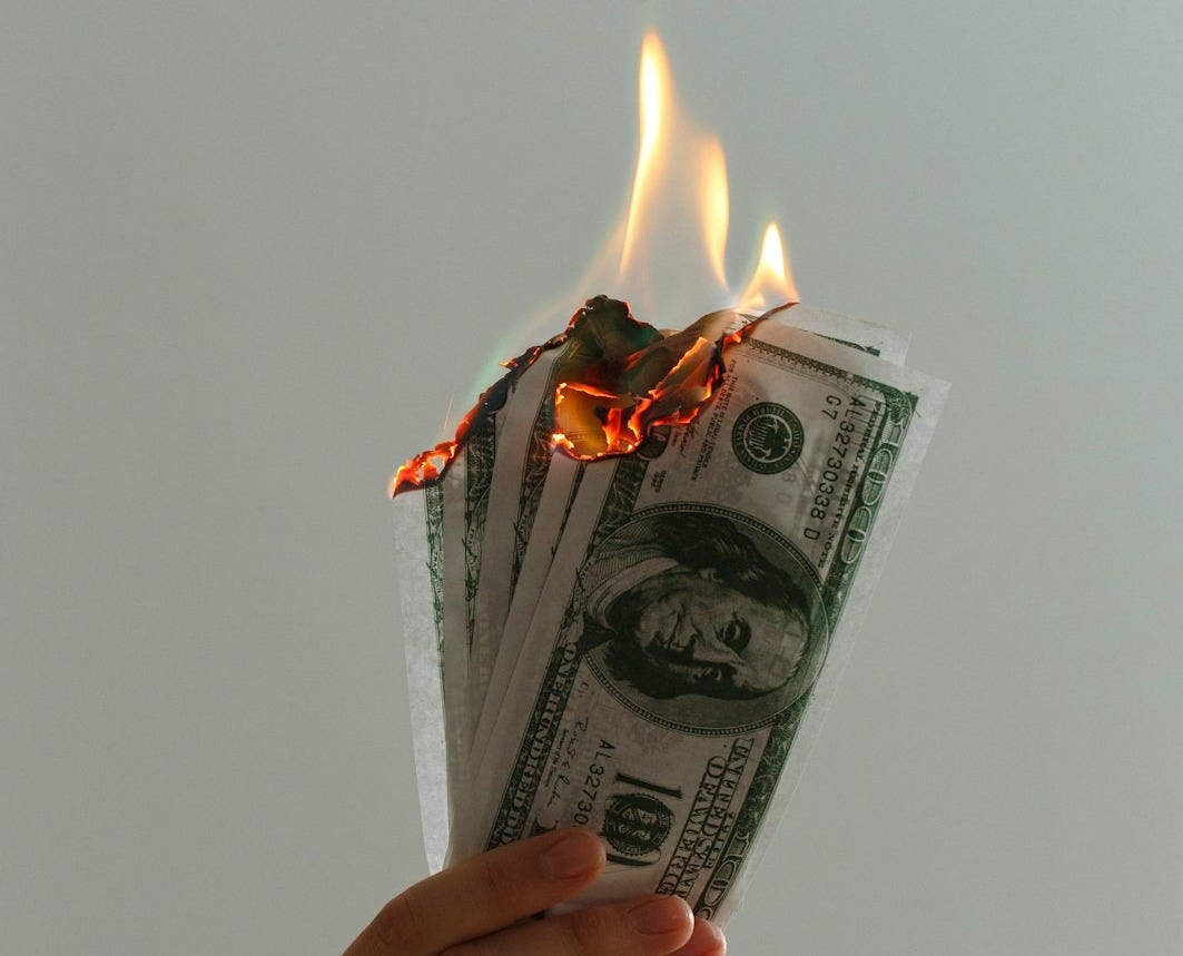 time lapse photography of several burning US dollar banknotes time lapse photography of several burning US dollar banknotes