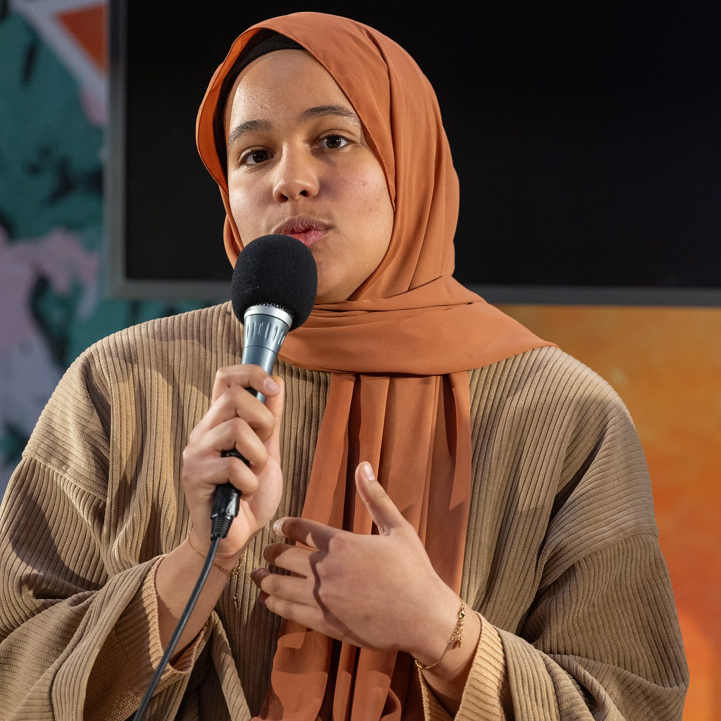Hélène Bâ lors du Festival Hors Pistes des Dégommeuses en janvier 2024. Elle parle au micro et porte un foulard orangé et un haut beige.