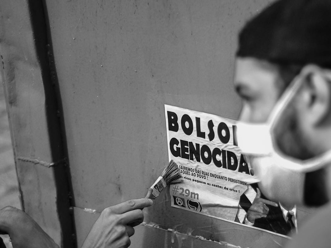 a man with a mask on putting a newspaper in a box a man with a mask on putting a newspaper in a box