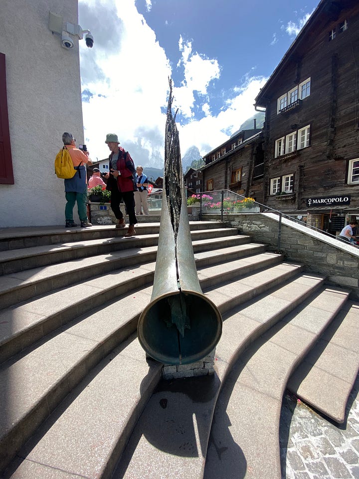 One of the plaques in the Walk of Climb, the Ibex fountain and the Matterhorn Museum, the Marmot fountain, and the Bronze Alphorn, which is pointed directly at the Matterhorn