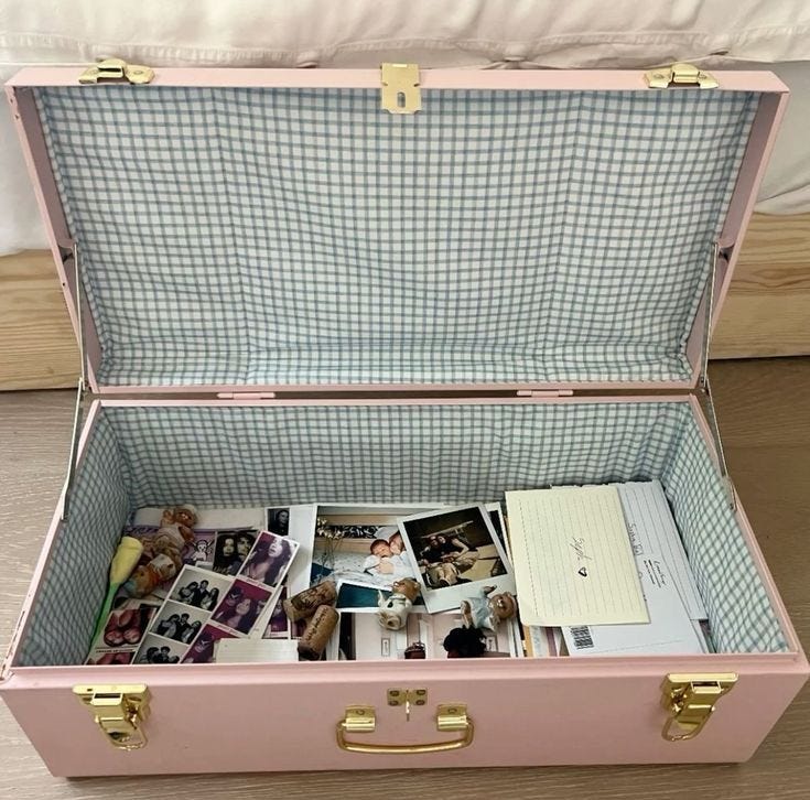 This may contain: an open pink suitcase filled with pictures and photos