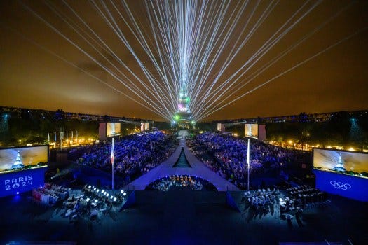Overview of the Trocadero venue, with the Eiffel Tower looming in the background 
and lasers lighting up the sky, during the opening ceremony of the Paris 2024 Olympic Games on July 26, 2024 (Photo by François-Xavier MARIT / AFP) (Photo by FRANCOIS-XAVIER MARIT/AFP via Getty Images)