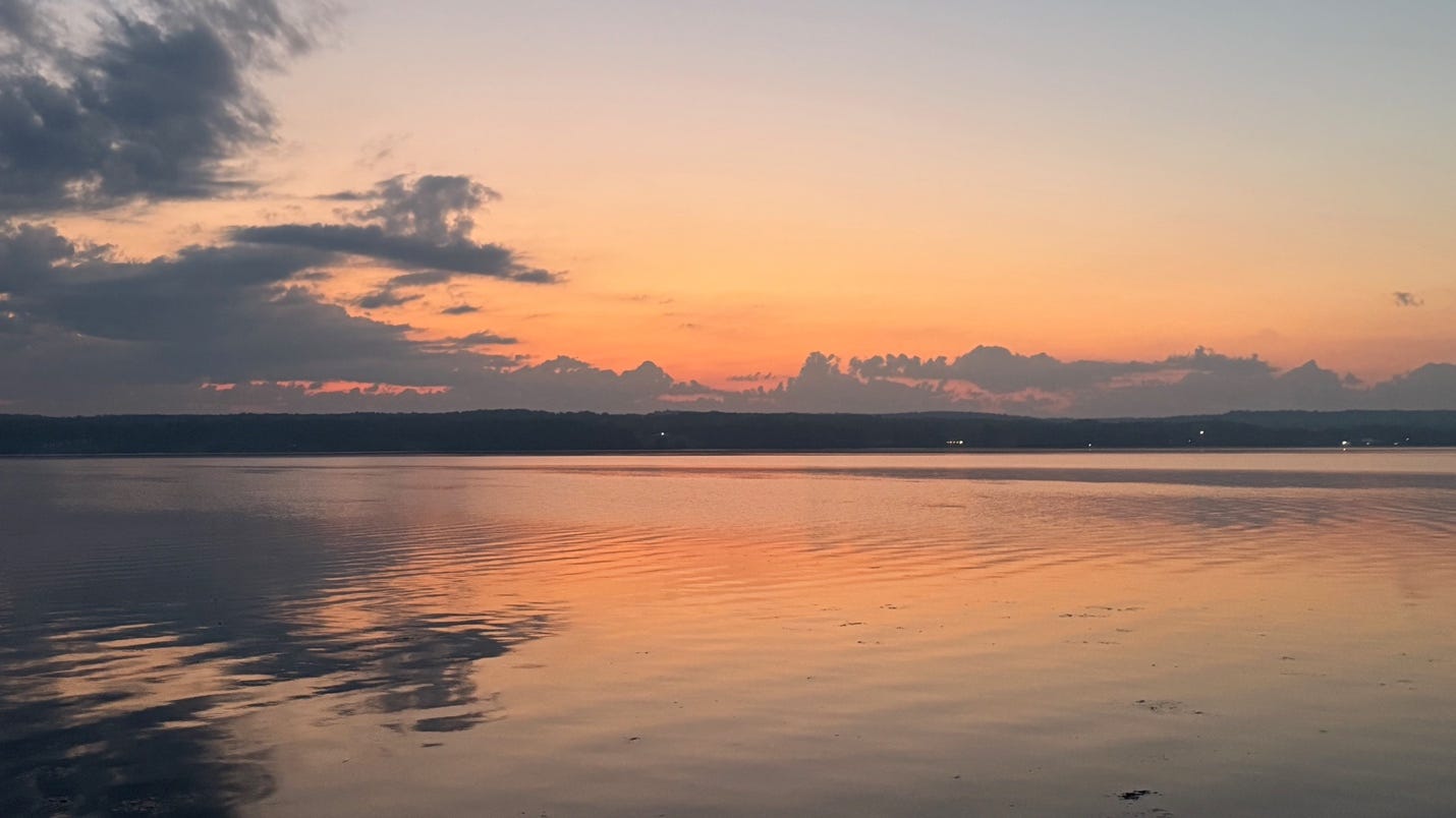 A body of water with a sunset in the background

AI-generated content may be incorrect.