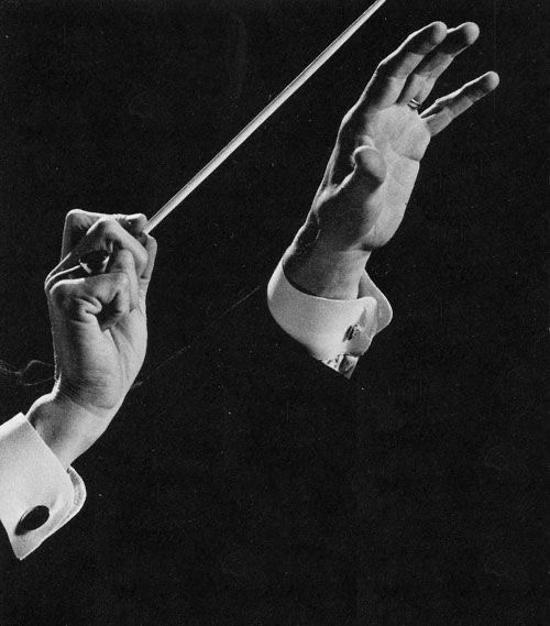 This may contain: an old black and white photo of two hands holding a conductor's batons