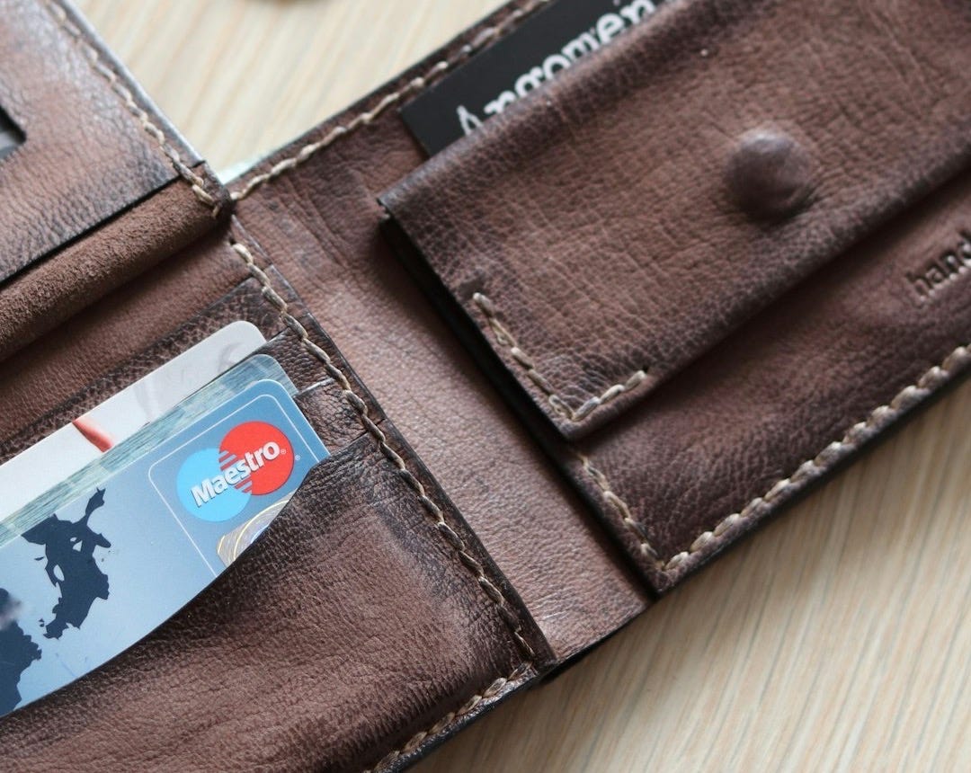 brown leather bifold wallet with coins and coins