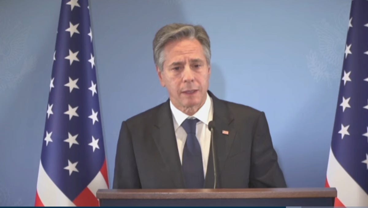 Antony Blinken speaking with U.S. flags to his left and right. Antony Blinken speaking with U.S. flags to his left and right.
