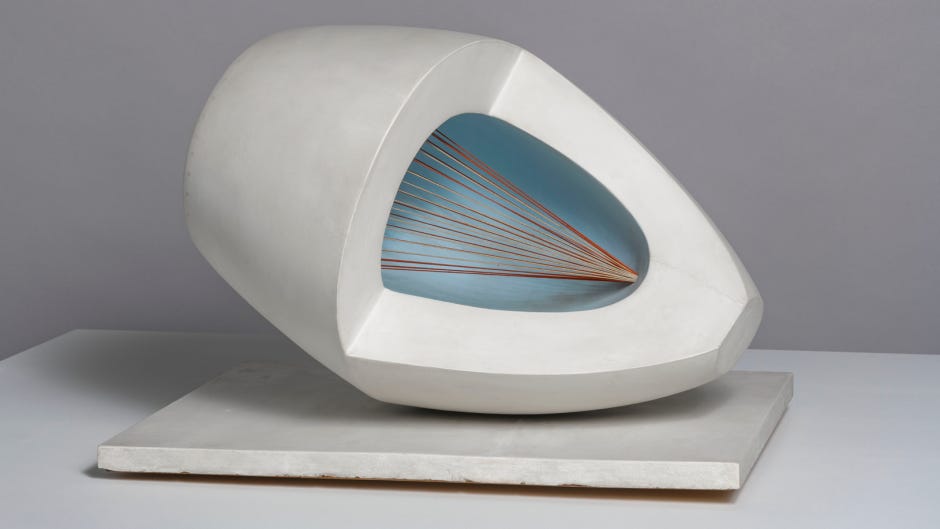 a wooden abstract sculpture featuring an oval form with pale blue and red painted surfaces, intersected by strings and mounted on a painted wooden base.
