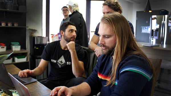 Mentors chat while cohort student McJam gets down on the curriculum!