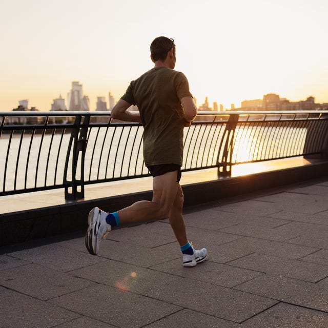 Mature man running along the river thames at sunset in london Mature man running along the river thames at sunset in london