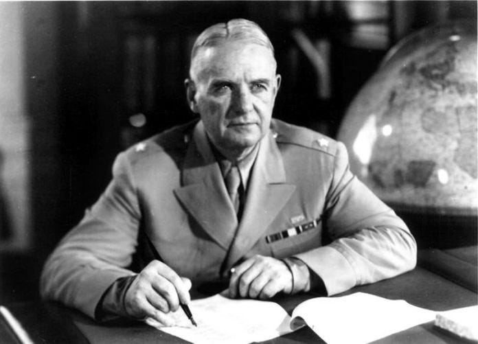 A person in a military uniform writing on a piece of paper

Description automatically generated