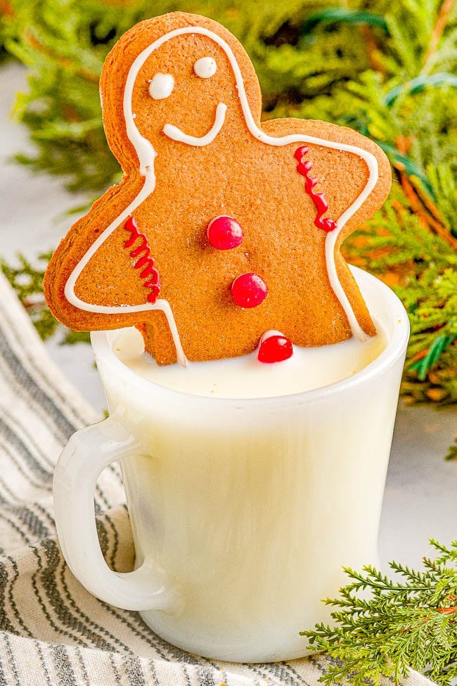 Classic Chewy Gingerbread Cookie sticking out of a mug of milk. Classic Chewy Gingerbread Cookie sticking out of a mug of milk.