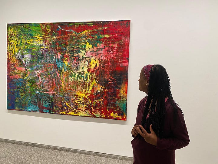 A colorful painting by artist Gerhard Richter, with splashes of yellow, green, blue, orange, pink and red, evoking a sense of joy.