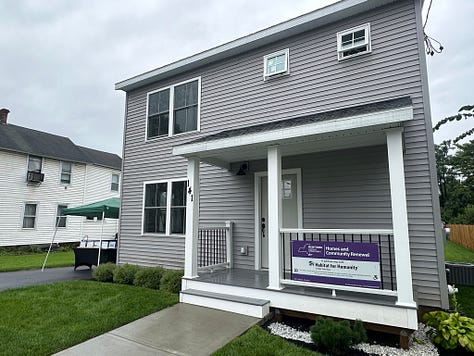 Pictures of a rebuilt house and the people who came by for the grand opening.