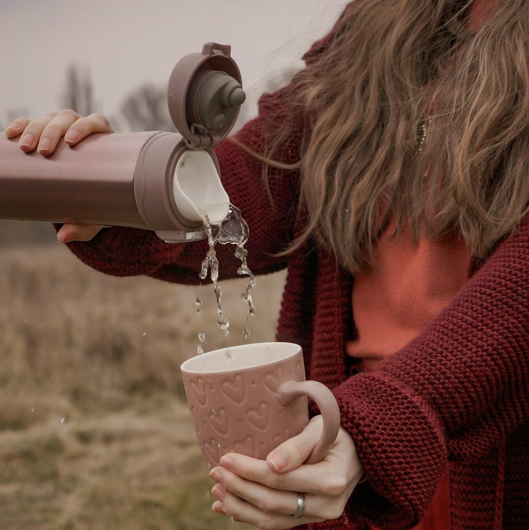 woman in red sweater holding white and brown ceramic mug woman in red sweater holding white and brown ceramic mug