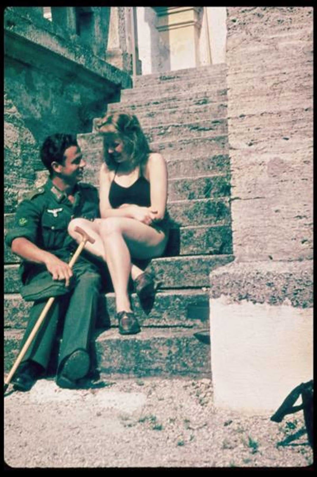 A rare color photograph of a Wehrmacht soldier and his companion. His cane suggests recuperation, a time when soldiers often formed relationships with local women. A rare color photograph of a Wehrmacht soldier and his companion. His cane suggests recuperation, a time when soldiers often formed relationships with local women.