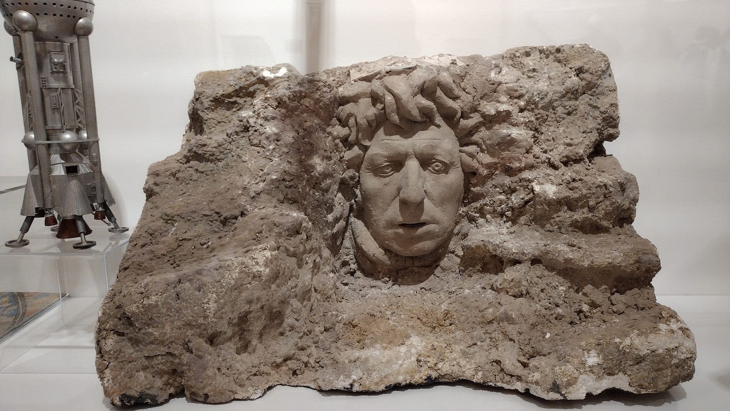 A model of a cliff with the face of Dr Who (Tom Baker) protruding from it