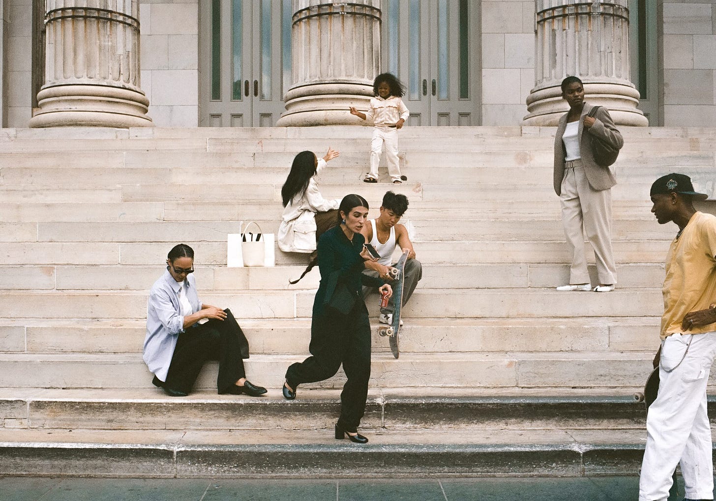 People gathered on a city sidewalk, paused mid-conversation, photographed documentary-style.