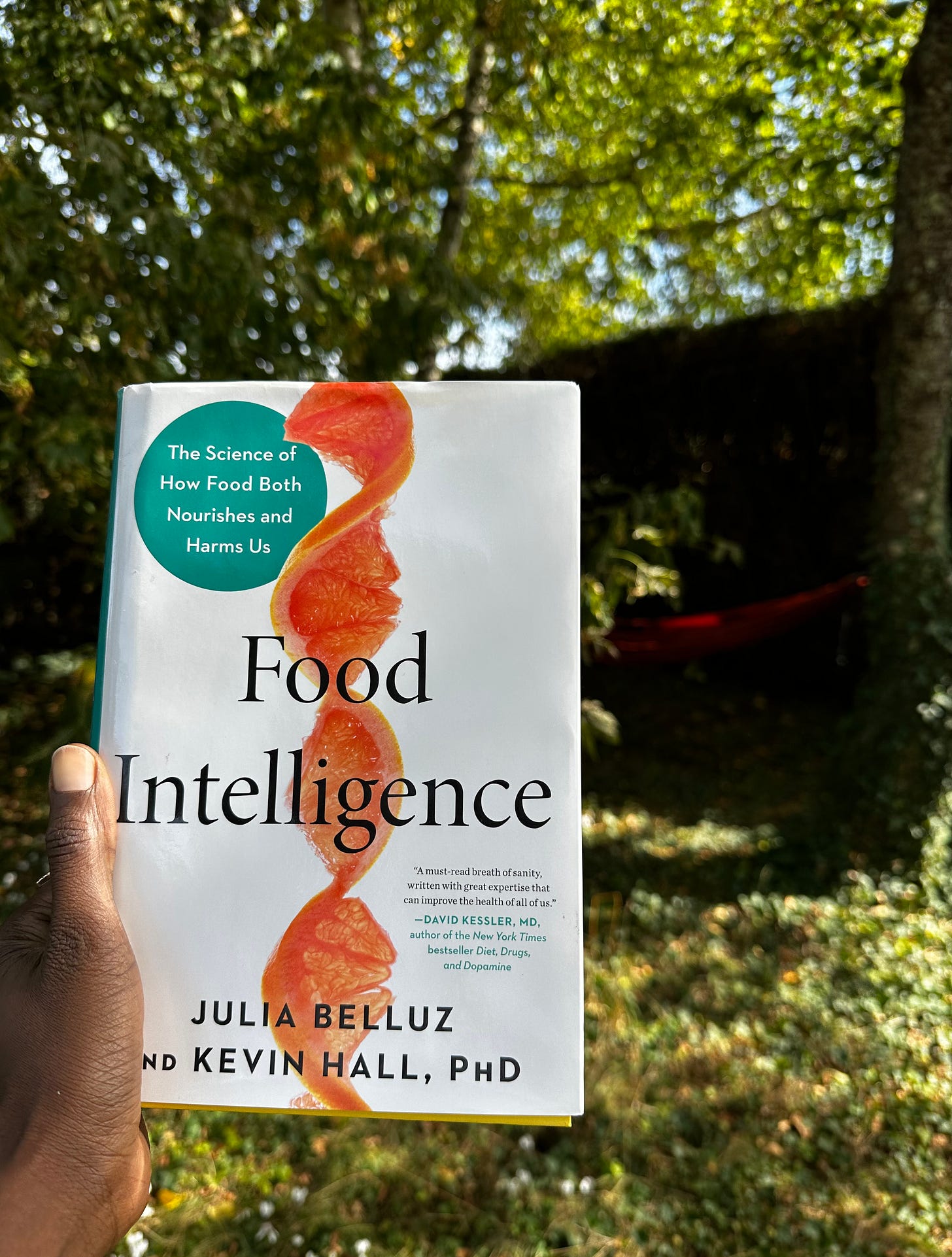 Hardcover copy of Food Intelligence by Julia Belluz and Kevin Hall, held outdoors in natural light Hardcover copy of Food Intelligence by Julia Belluz and Kevin Hall, held outdoors in natural light