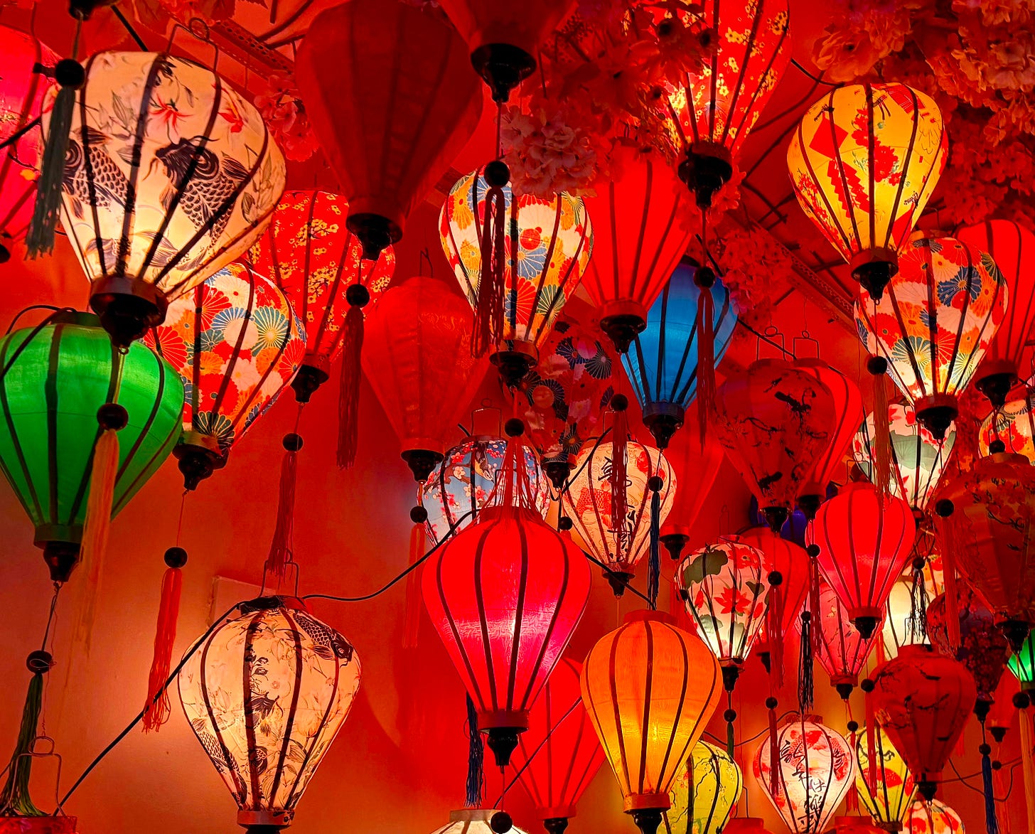 lots of coloured Vietnamese fabric lamps, mainly red