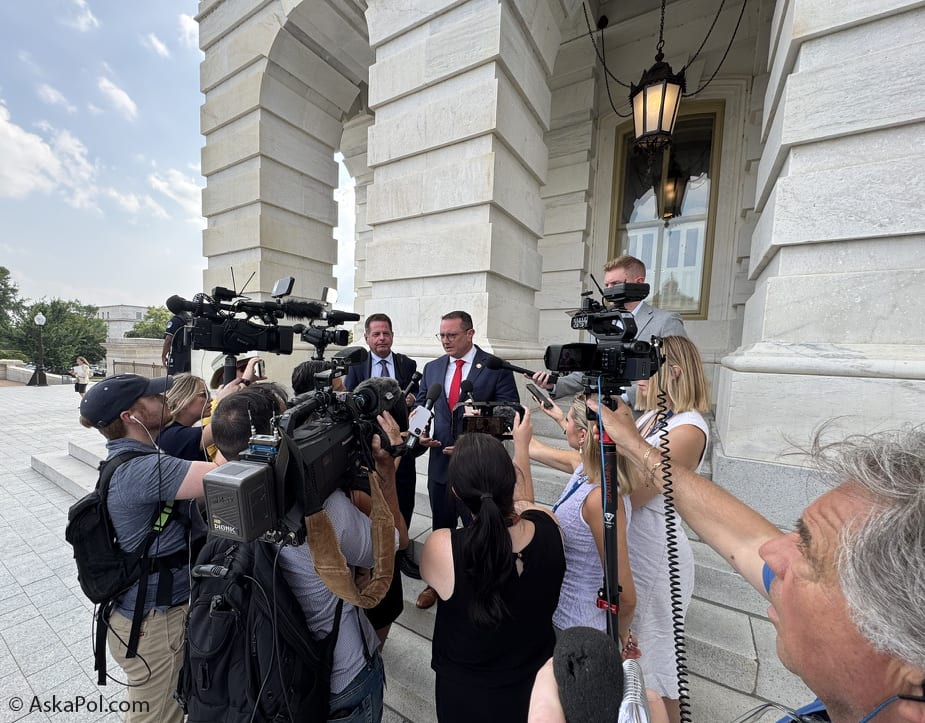 Cameras and microphones record a man in a suit and red ties. Photo: Matt Laslo © AskaPol.com