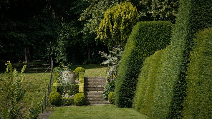 a tranquil oasis of neatly trimmed hedges and vibrant blooms