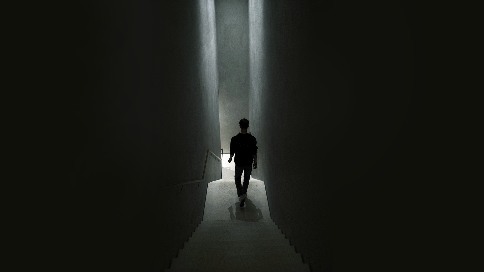 A person walking down a dark staircase A person walking down a dark staircase