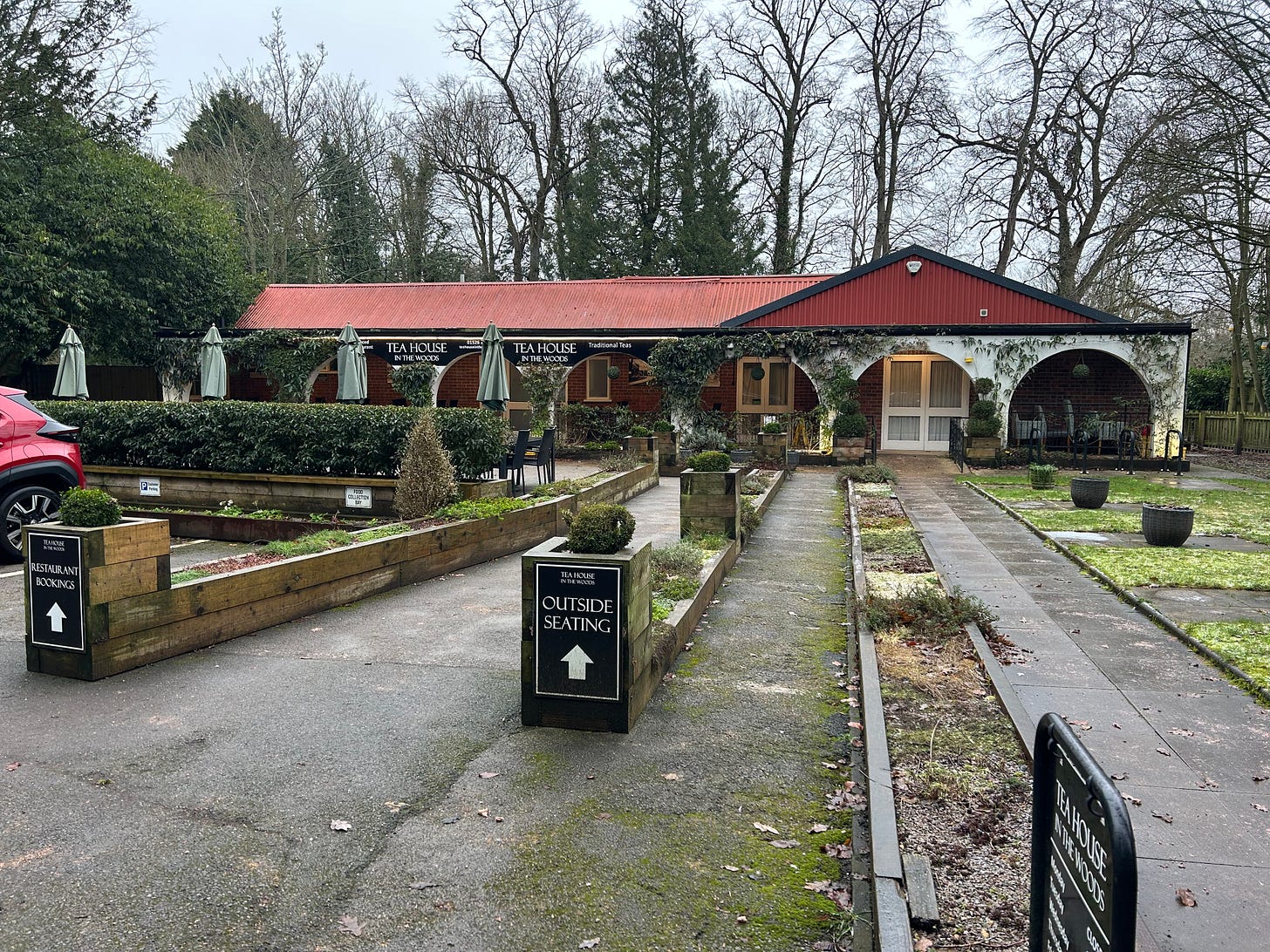 The Tea House in the Woods, Woodhall Spa. As seen from the road. A row of parasols are folded up. There is no point in sitting out in the January rain. 