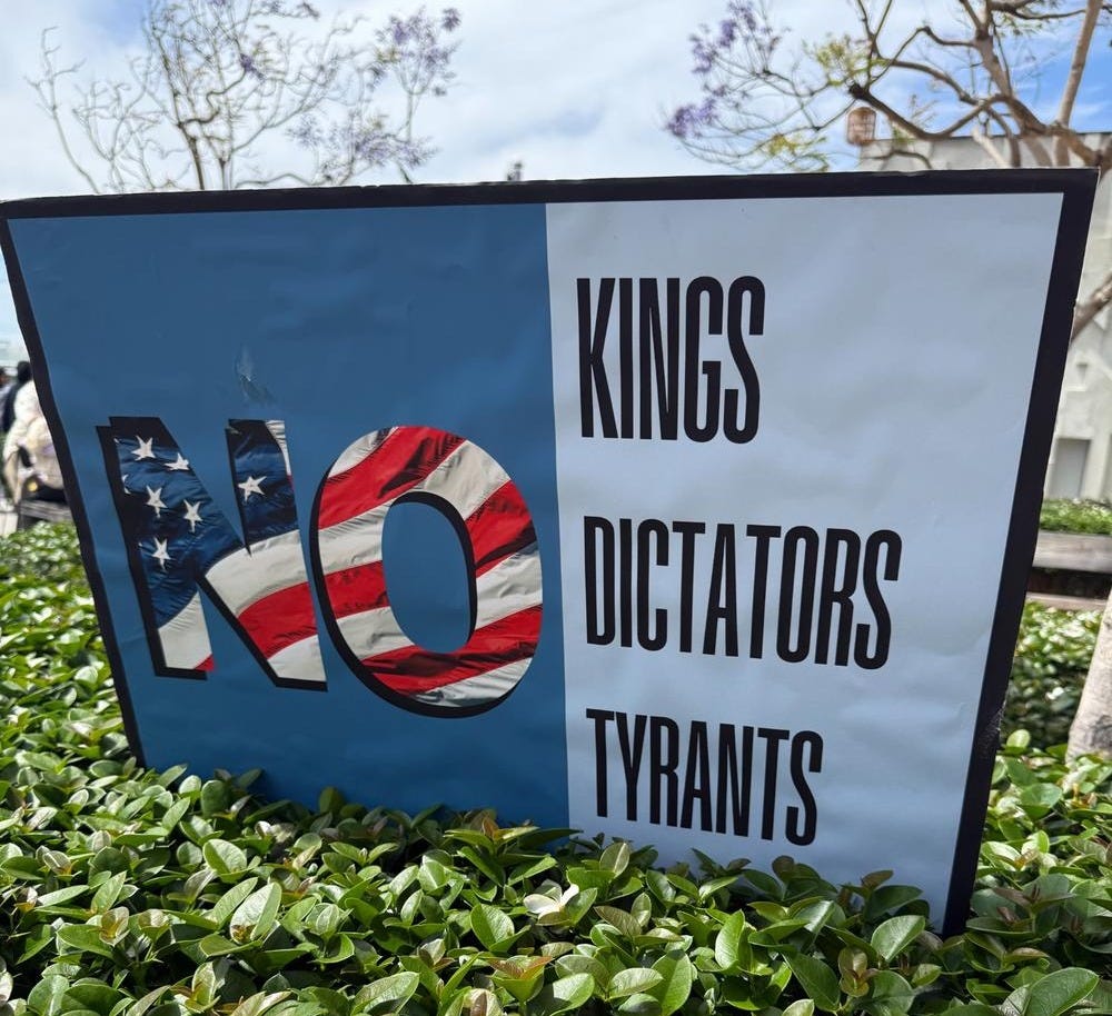 Photo of protest sign reading ‘No Kings, Dictators, Tyrants'