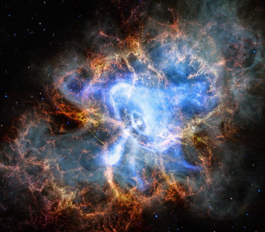A cloud of material that resembles roaring fire, in shades of mostly red and orange. In the center of the nebula is a structure that resembles the shape of a spinning toy top, made of blue and white wispy clouds, resting on its side. The top-like shape is outlined by feathery shrouds of electric blue light. In the center, where the point of the toy top shape meets its flared body, is a ball of brilliant white light. This is the neutron star at the heart of the Crab Nebula. Concentric circles surround the star, as if the star was a small pebble that was dropped into a puddle of water. From the bottom of the neutron star, a jet of matter is rushing downward, like scalding h A cloud of material that resembles roaring fire, in shades of mostly red and orange. In the center of the nebula is a structure that resembles the shape of a spinning toy top, made of blue and white wispy clouds, resting on its side. The top-like shape is outlined by feathery shrouds of electric blue light. In the center, where the point of the toy top shape meets its flared body, is a ball of brilliant white light. This is the neutron star at the heart of the Crab Nebula. Concentric circles surround the star, as if the star was a small pebble that was dropped into a puddle of water. From the bottom of the neutron star, a jet of matter is rushing downward, like scalding h