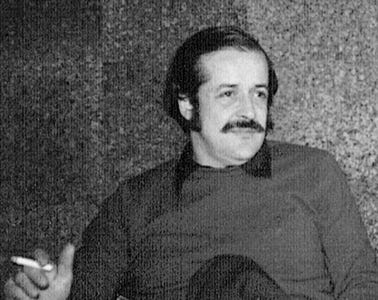A person with a mustache and a cigarette

Description automatically generated