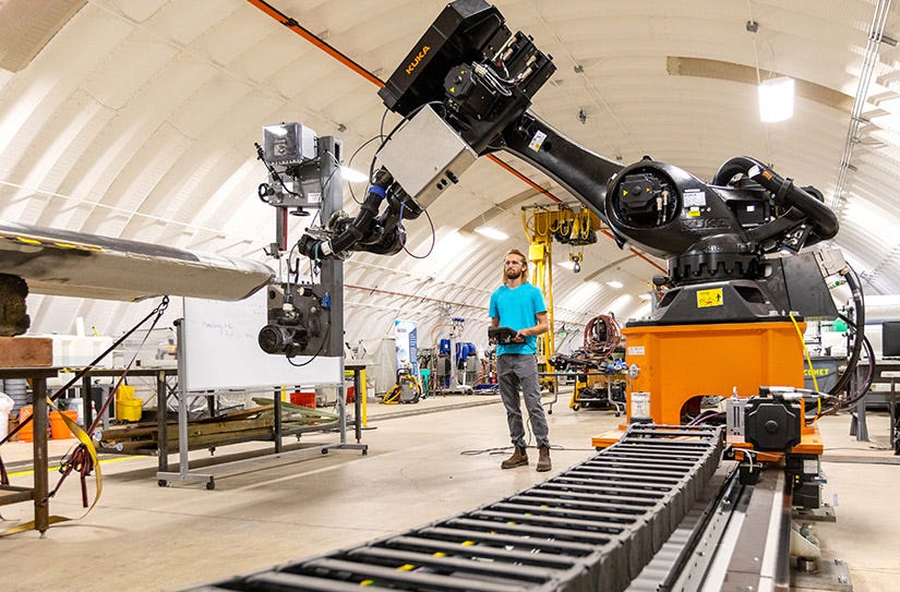 A man stands next to a piece of machinery.