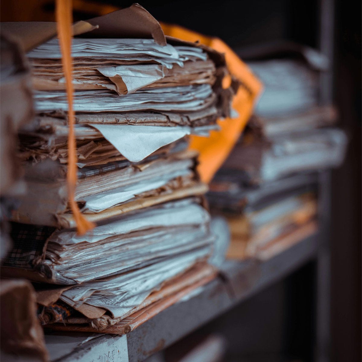 Folders of papers on a shelf. Image via Srijonism