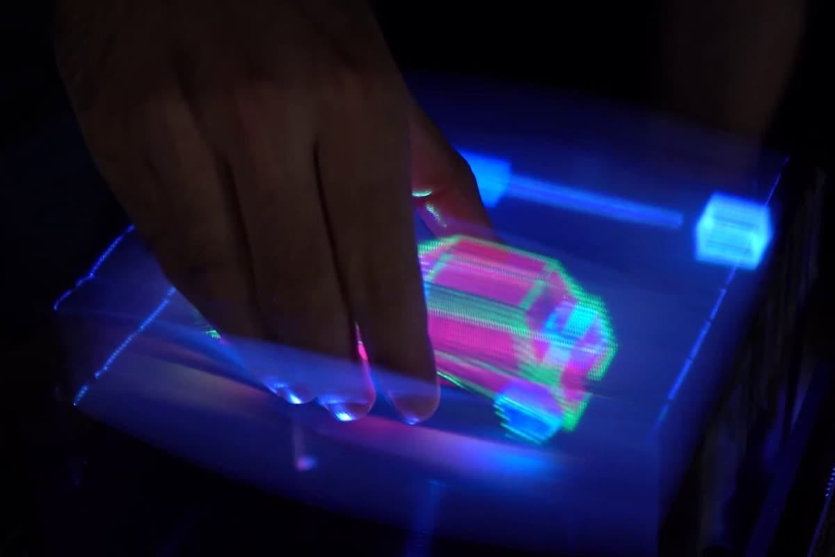 A user is able to "grab" the car hologram and manipulate it
