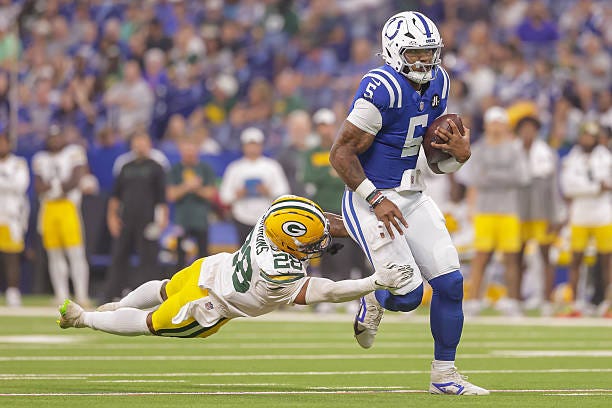 Anthony Richardson Sr. #5 of the Indianapolis Colts runs the ball as Isaiah Simmons of the Green Bay Packers reaches for the tackle during the NFL...