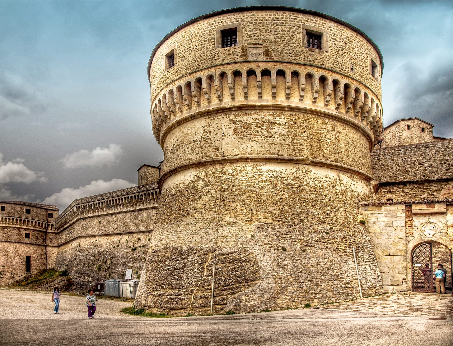 The round tower of the Fortress of San Leo built from stone bricks and natural rock. The round tower of the Fortress of San Leo built from stone bricks and natural rock.