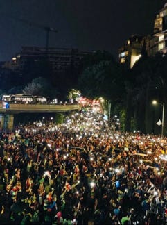 A large crowd of people on a street

Description automatically generated