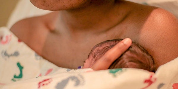 close up photograph of the top of a premature baby's head resting skin to skin on its mother's chest