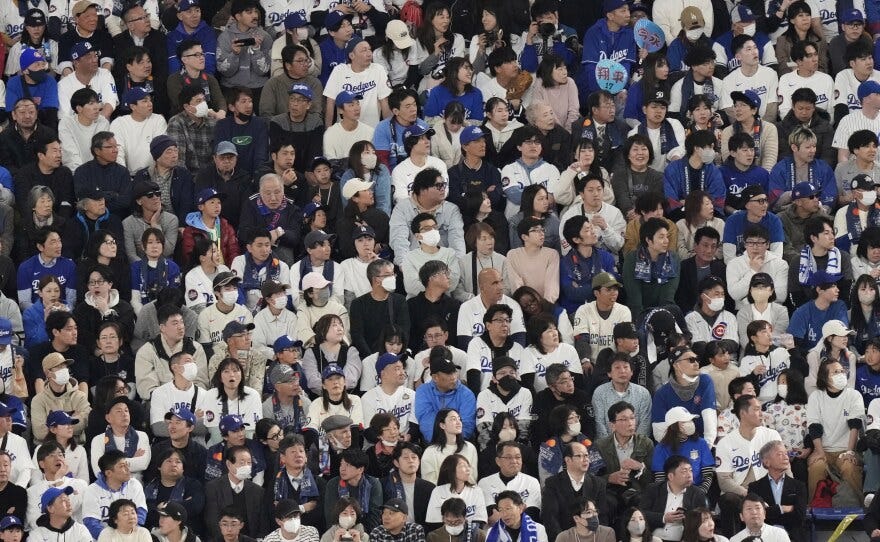 Fans watch the Los Angeles Dodgers play the Chicago Cubs in the first inning of an MLB Japan Series baseball game in Tokyo, Japan, Tuesday, March 18, 2025. (AP Photo/Eugene Hoshiko)