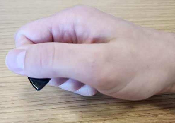 A hand holding a black object

Description automatically generated