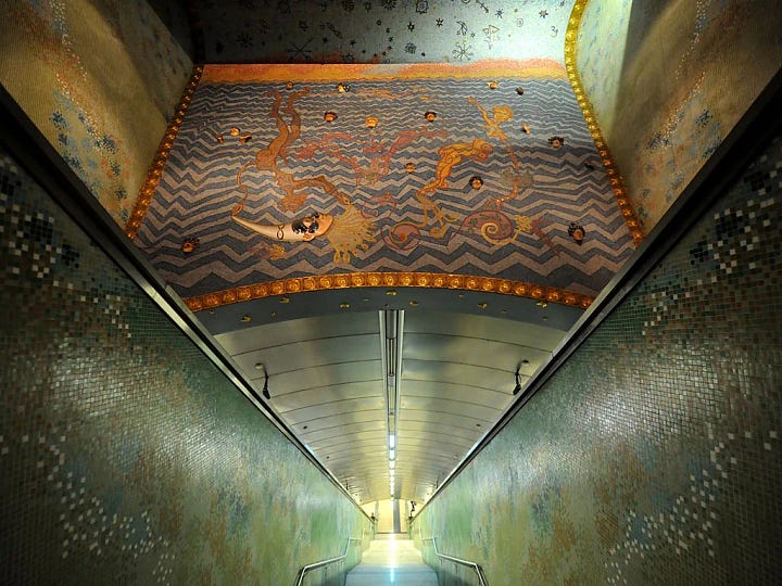 A four-image collage showing ornate and immersive metro stations around the world, including blue painted escalator walls, patterned vaulted ceilings, tiled station interiors, and a train platform with decorative lighting.
