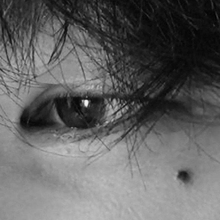 This may contain: a close up of a person's eye with long hair