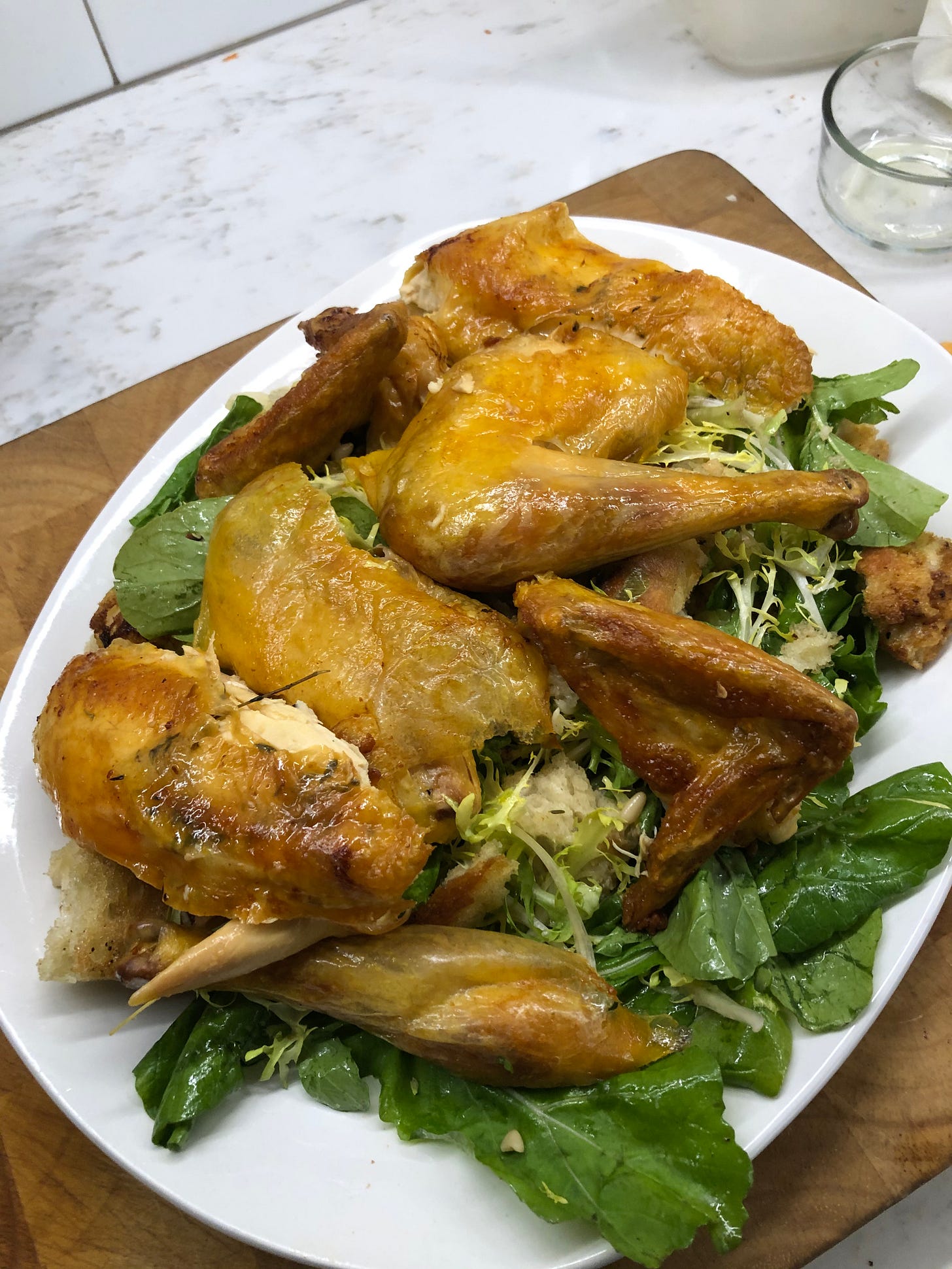 The carved chicken on top of a bread and lettuce salad